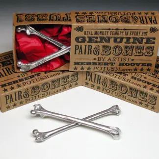 Lifelike replica of a pair of human femur bones in miniature cast in pewter and polished to a matte finish
